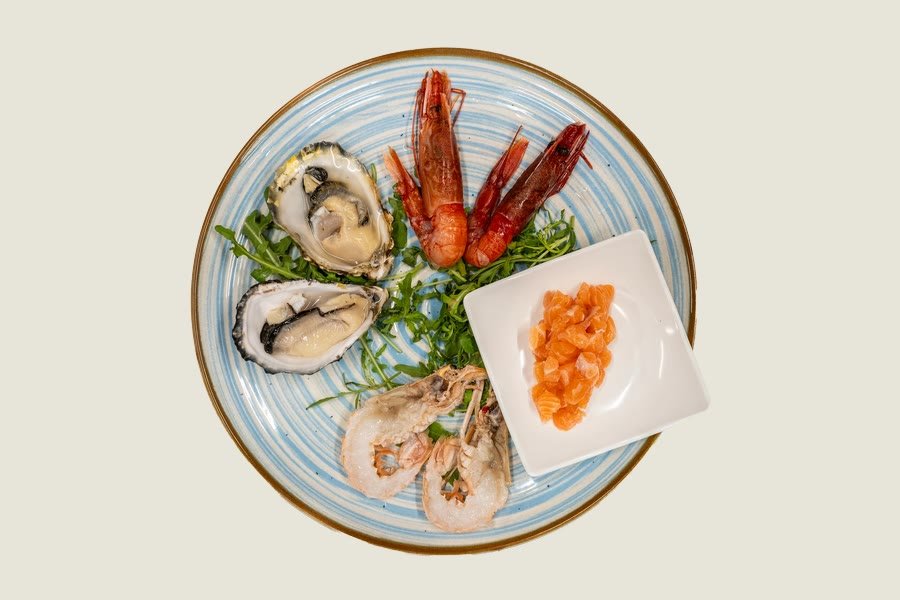 Plateau di mare visto dall'alto con ostriche, gamberi rossi e tartare di salmone